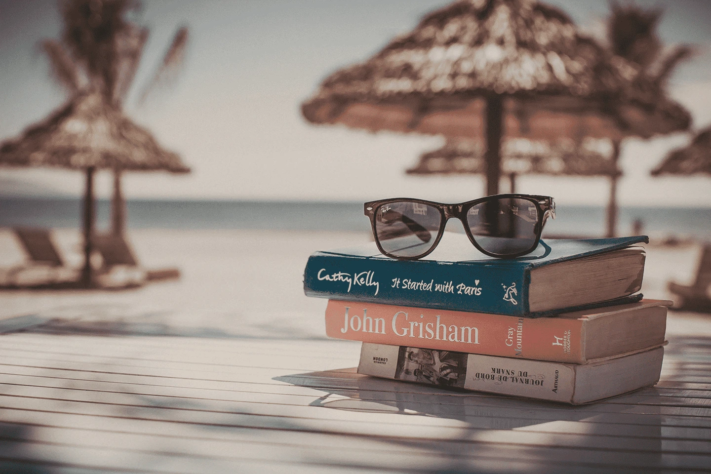 Vacation photo by the beach, sunglasses and books